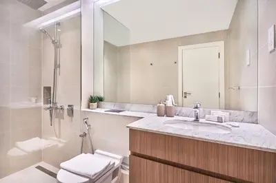 a bathroom with a sink and a shower and a toilet at Le Pont Apartment in Port de La Mer with Pool Access, Retreat near the Beach in Dubai