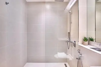 a bathroom with a shower and a sink at Le Pont Apartment in Port de La Mer with Pool Access, Retreat near the Beach in Dubai