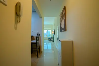 a hallway leading to a kitchen and a dining room at Metrofront Stay - Walk to Iconic Dubai Spots in Dubai