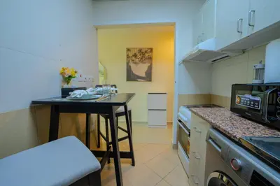 a small kitchen with a table and a counter top at Metrofront Stay - Walk to Iconic Dubai Spots in Dubai