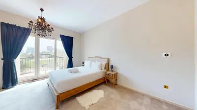 a bedroom with a bed and a large window at Vacationer l Family Villa with Private Pool, Private Garden in Dubai