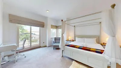 a bedroom with a bed and a desk and a window at Vacationer l Family Villa with Private Pool, Private Garden in Dubai