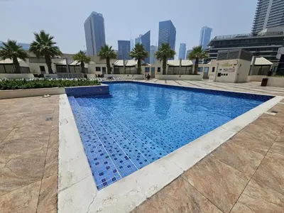 a swimming pool in a city with tall buildings at SUNRISE HOMES - Stunning 1BR Marina View near Beach walk in Dubai