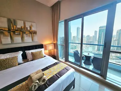 a hotel room with a bed and a large window at SUNRISE HOMES - Stunning 1BR Marina View near Beach walk in Dubai
