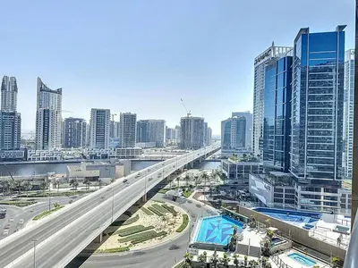 a bridge over a highway in a city with tall buildings at Stylish Studio in Elite Downtown in Dubai