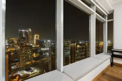 a balcony with a view of a city at night at Luxury 1BR with Workspace Next To Dubai Mall in Dubai