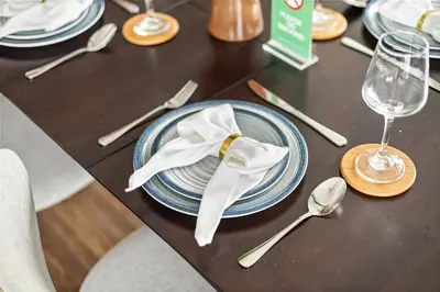 a table with a blue plate with a white napkin at Luxury 1BR with Workspace Next To Dubai Mall in Dubai