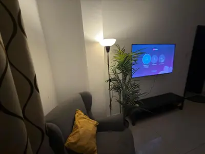 a living room with a chair and a tv at Marina View Retreat 1BR In Escan Tower Marina in Dubai