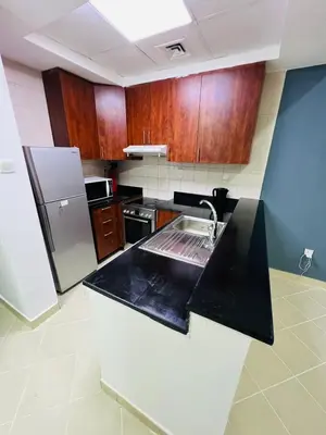 a kitchen with wooden cabinets and a black counter top at Marina View Retreat 1BR In Escan Tower Marina in Dubai