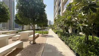 a park with benches and trees and a building at Luxury 2BR- Pool with Burj View- 5 Min to Dubai Mall in Dubai