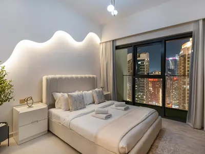 a bedroom with a large bed with a large window at Luxury 2BR- Pool with Burj View- 5 Min to Dubai Mall in Dubai