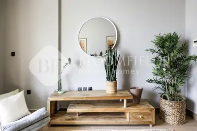 a living room with a table and a mirror at Bloomfields Marquis 2020 in Arjan in Dubai