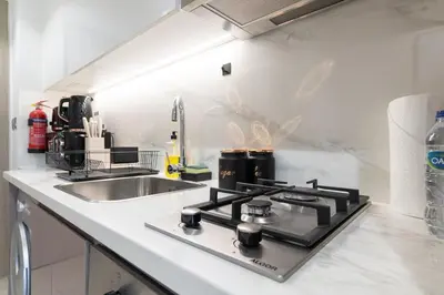 a kitchen with a stove and a sink at Downtown-Close Studio by Czech-In in Dubai