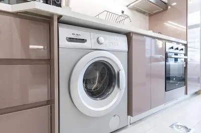 a washing machine in a kitchen next to a counter at Downtown-Close Studio by Czech-In in Dubai