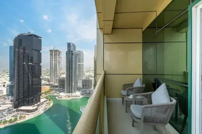 a balcony with chairs and a view of a city at Samaya Holiday Homes - Lake City Stunning Suits Lake View - Next to Metro in Dubai