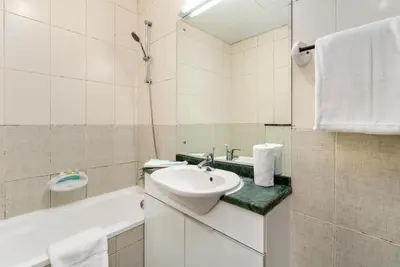 a white bathroom with a sink and a bath tub at Samaya Holiday Homes - Lake City Stunning Suits Lake View - Next to Metro in Dubai