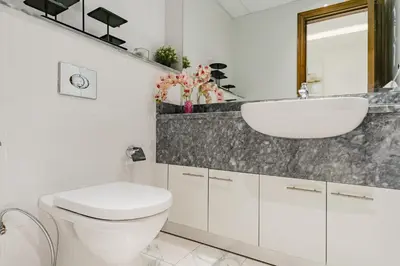 a white bathroom with a sink and a toilet at RH Luxe Vibes 2BR Al Habtoor City, Mesmerizing Canal View in Dubai