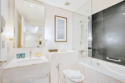 a white bathroom with a sink and a toilet at PVH - Emaar Residences - Burj Khalifa View Studio in Dubai