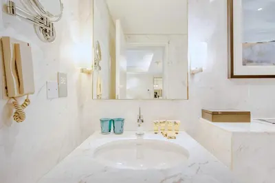 a white bathroom with a sink and a mirror at PVH - Emaar Residences - Burj Khalifa View Studio in Dubai