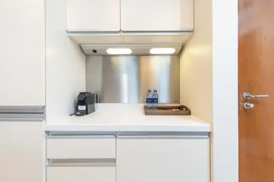 a kitchen with white cabinets and a counter top at PVH - Dubai Mall Access 1BR - Emaar Fashion Avenue in Dubai