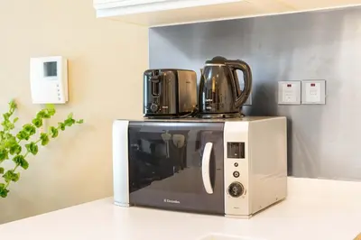 a microwave with two coffee cups on top of it at PVH - Dubai Mall Access 1BR - Emaar Fashion Avenue in Dubai