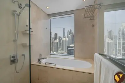 a bathroom with a bath tub and a window at Vogue Marina JW Marriott with Direct Access to Marina Mall, Studio Apartment with Balcony and Marina Skyline View, Access to all Amenities in Dubai