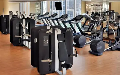 a gym with rows of treadmills and exercise equipment at Vogue Marina JW Marriott with Direct Access to Marina Mall, Studio Apartment with Balcony and Marina Skyline View, Access to all Amenities in Dubai