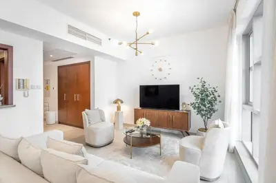 a living room with white furniture and a flat screen tv at Boema Apartments- Luxury with Burj Khalifa View in Dubai