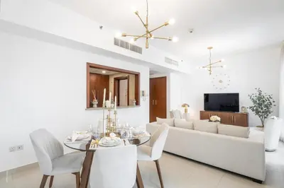 a living room with a table and a white couch at Boema Apartments- Luxury with Burj Khalifa View in Dubai