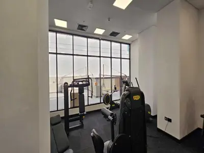 a gym with a large window and cardio machines at Beautiful Studio in Jumeirah Village Circle in Dubai