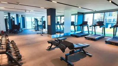 a gym with several treadmills and exercise bikes at FAM Living Stylish 1BR in Nobles Tower Near Downtown in Dubai