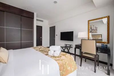 a bedroom with a bed with a desk and a mirror at LUX The JW Marina Suite 4 in Dubai