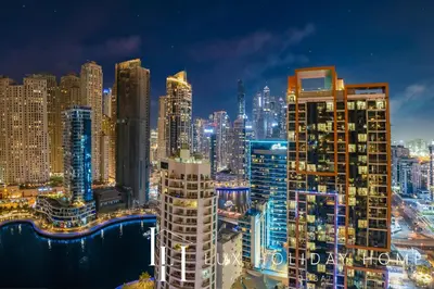 a view of a city at night at LUX The JW Marina Suite 4 in Dubai