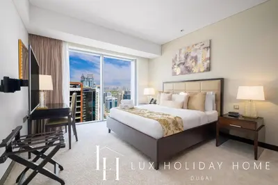 a bedroom with a bed and a desk and a window at LUX The JW Marina Suite 4 in Dubai