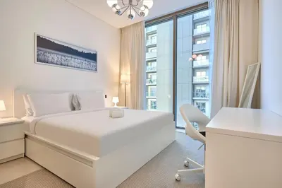 a white bedroom with a white bed and a desk at STAY BY LATINEM Luxury 2BR Holiday Home CVR B405 Near Burj Khalifa in Dubai