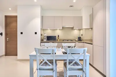 a kitchen with a white table and chairs at STAY BY LATINEM Luxury 2BR Holiday Home CVR B405 Near Burj Khalifa in Dubai