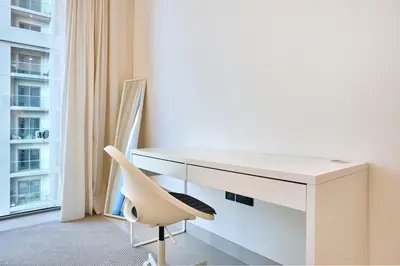 a white desk and a chair in a room with a window at STAY BY LATINEM Luxury 2BR Holiday Home CVR B405 Near Burj Khalifa in Dubai