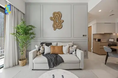 a living room with a couch and a kitchen at The Ivory Crown 1BR Downtown Dubai in Dubai
