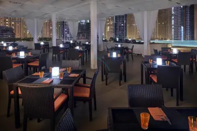 a restaurant with tables and chairs and a view of the city at Luxury 1BR with Breathtaking Dubai Water Canal Views, Just Beside Dubai Marina Mall and Tram, Near JBR Beach, The Address Residences, Dubai Marina by Deluxe Holiday Homes in Dubai