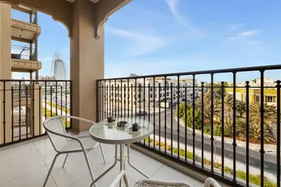 a balcony with a table and chairs and a view at Stylish 1BR with Balcony and Burj AlArab View in Dubai