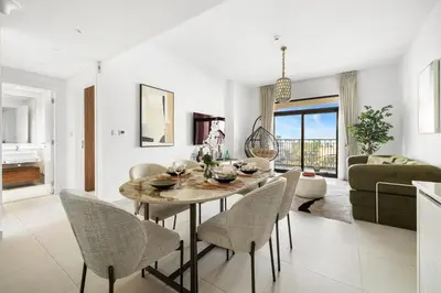 a dining room and living room with a table and chairs at Stylish 1BR with Balcony and Burj AlArab View in Dubai