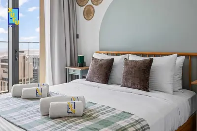 a bedroom with a bed with pillows and a window at Celestial & Curated 1BR Downtown Dubai in Dubai