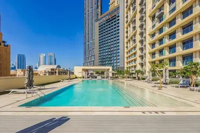 a swimming pool with chairs and a building at Celestial & Curated 1BR Downtown Dubai in Dubai