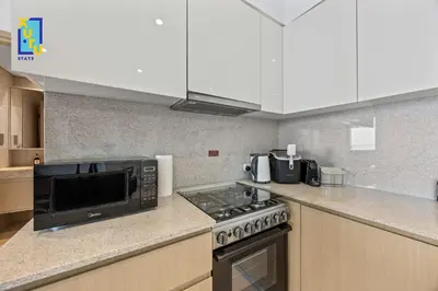 a kitchen with a microwave and a stove at Celestial & Curated 1BR Downtown Dubai in Dubai