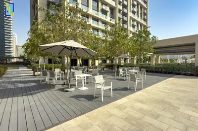 a patio with tables and chairs and an umbrella at Celestial & Curated 1BR Downtown Dubai in Dubai
