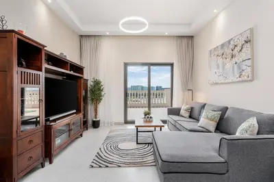 a living room with a couch and a tv at Elegant 2Bhk Panorama Apartment in Dubai