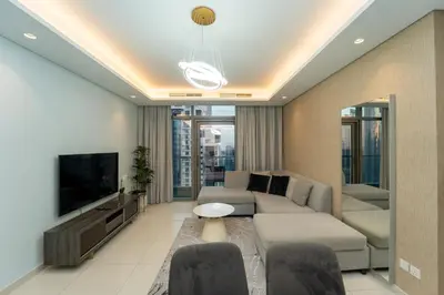 a living room with a couch and a tv at Paramount Hotel Midtown 2BR Apartment With Burj Khalifa View in Dubai
