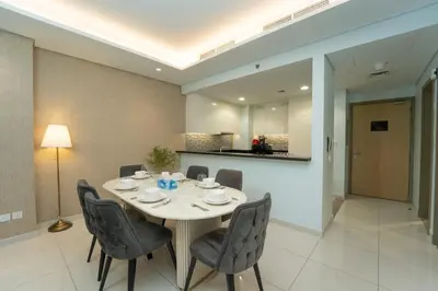 a dining room with a table and chairs at Paramount Hotel Midtown 2BR Apartment With Burj Khalifa View in Dubai