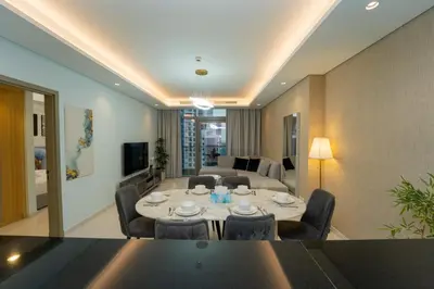 a living room with a table and chairs and a couch at Paramount Hotel Midtown 2BR Apartment With Burj Khalifa View in Dubai