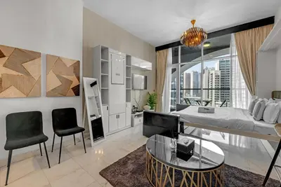 a living room with a bed and a table and chairs at Waves - Vibrant Studio, Perfect For Couples in Dubai